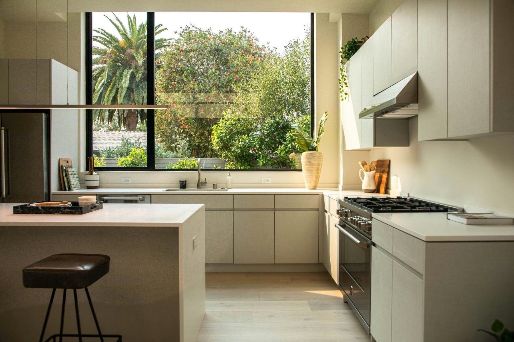 Cocina luminosa con mesón blanco y ventana al jardín